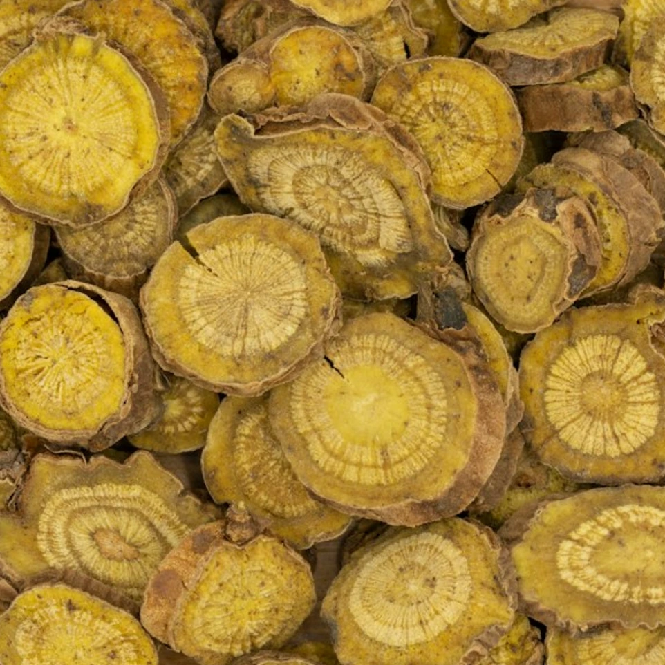 a wooden bowl filled with green vegetables on top of a white table